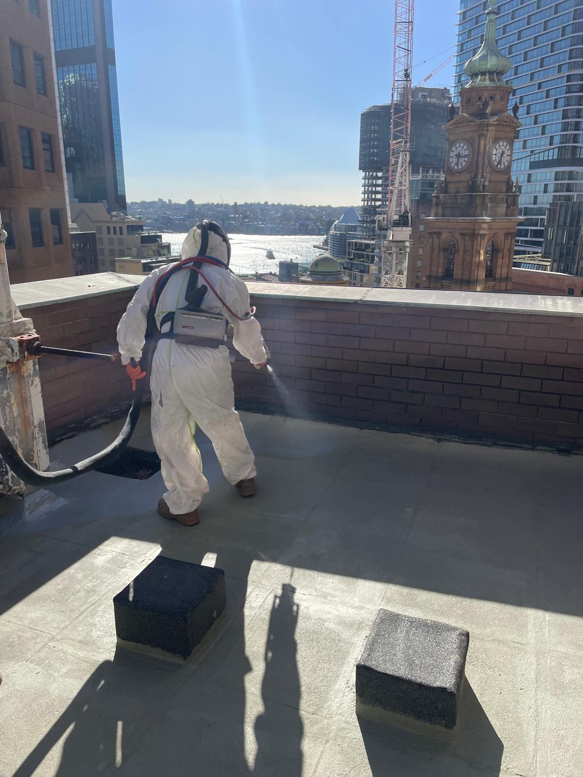 Hydro Logic technician applying industrial protective coating at Sydney CBD rooftop