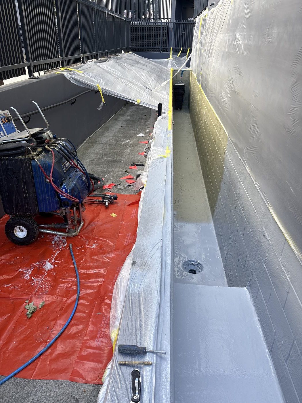 Heated plural-component spray equipment used to apply the planter box membrane